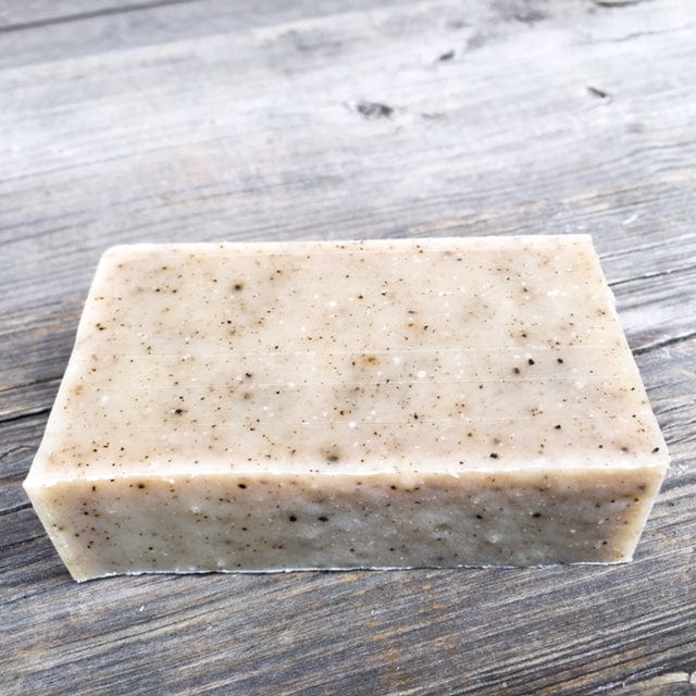 Bar of speckled soap on wood.